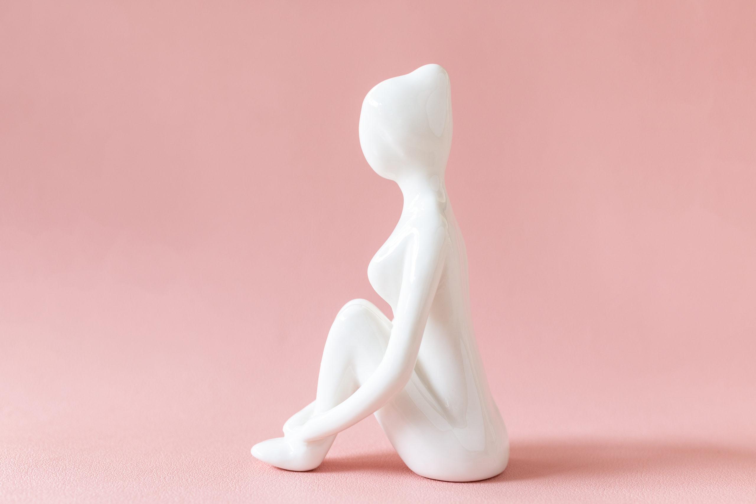 Ceramic Yoga Figurine of Woman doing yoga pose on pink backgroun Ceramic Yoga Figurine of Woman doing yoga pose on pink background