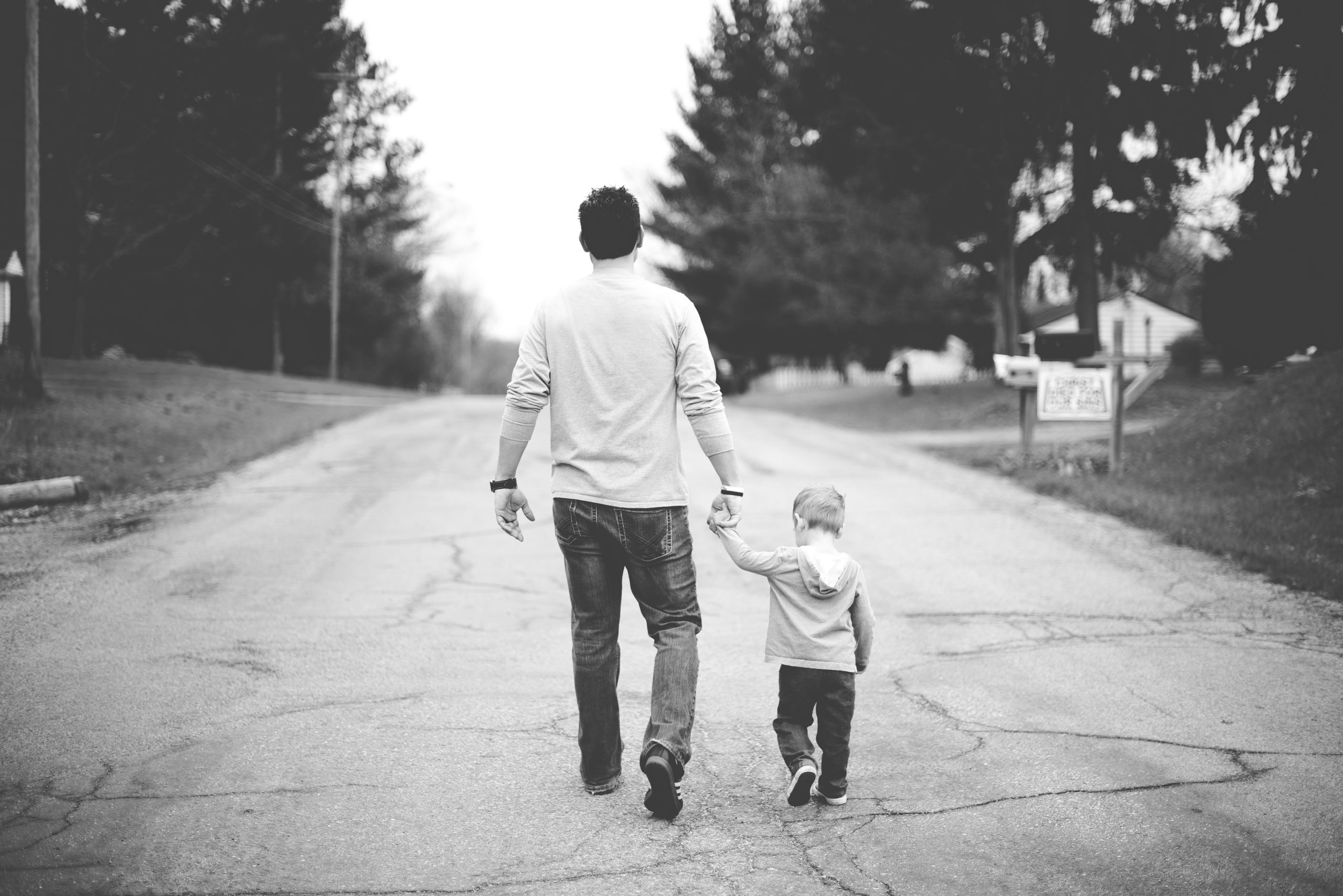 man holding baby’s hand man holding baby's hand