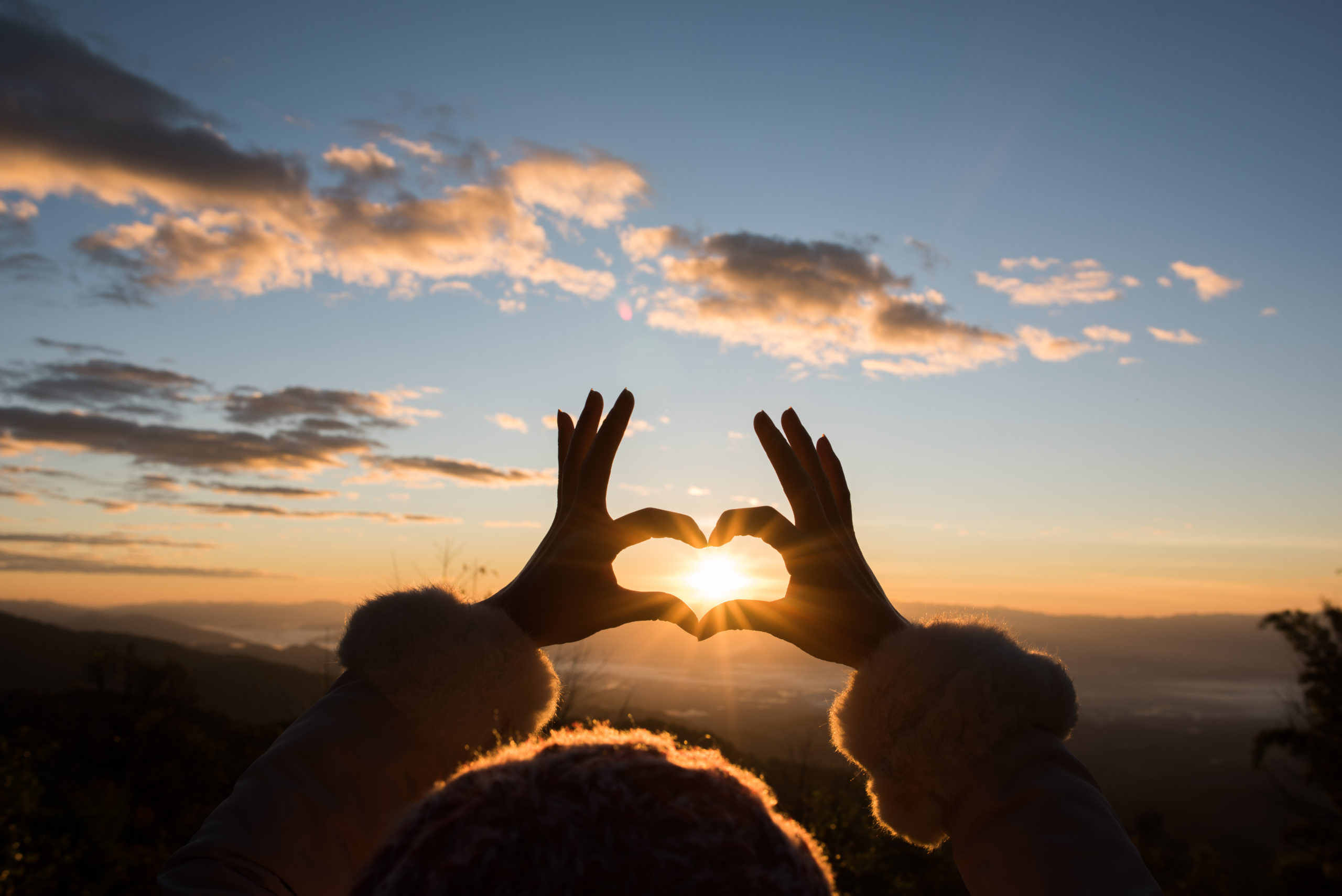 Silhouette hands forming a heart shape with sunrise Silhouette hands forming a heart shape with sunrise